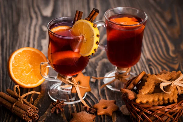 Warme glühwein met pittige kruiden en oranje. Citroen, kaneel en kardemom op een donkere houten achtergrond. — Stockfoto