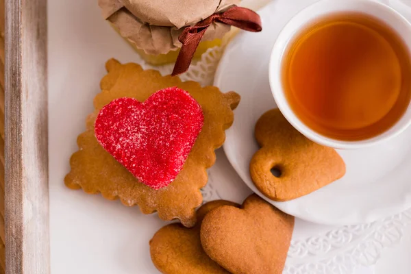 Teetasse mit herzförmigen Keksen vorhanden. Rote Zuckerkekse. — Stockfoto