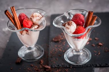 Bir cam bardak, çilek mus, tarçın ve çikolata koyu gri arka plan üzerinde taze çilek vanilyalı dondurma