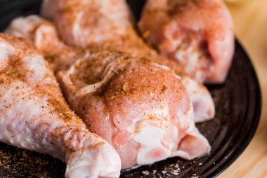 Tibia tavuk, tavuk budu siyah bir kaplama, ahşap arka plan, baharatlar ve tuz hazırlanması