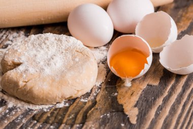 Ekmek pişirme işlemi. Pasta, ekmek, rulo ve bisküvi pişirme için hamur hazırlama. Ahşap koyu arka plan üzerinde yumurta ile un. Hamur için oklava yanındaki.