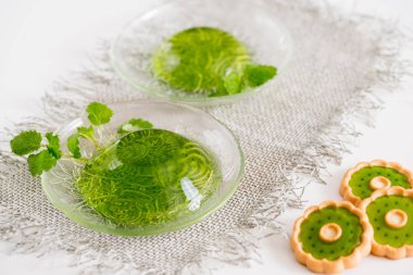 Yeşil jöle ile beyaz bir arka plan üzerinde keten peçeteye cam nane yaprakları.