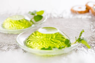 Yeşil jöle ile beyaz bir arka plan üzerinde keten peçeteye cam nane yaprakları.