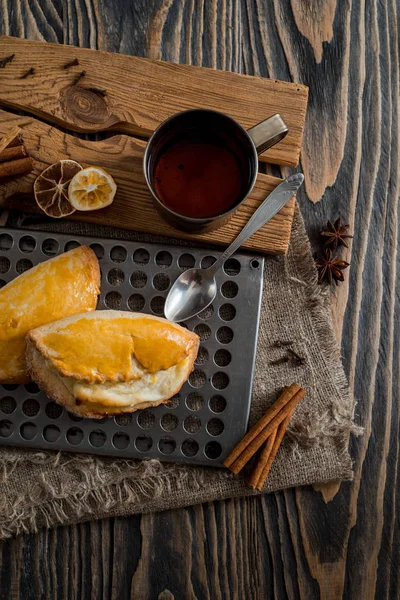 Taza de té caliente y bollos dulces en la mesa de madera. Vista superior — Foto de Stock