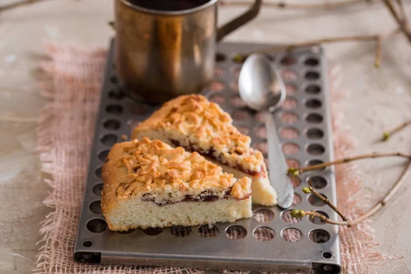 Stuk van cake van het Fruit met aardbei, kiwi, perzik, appel, custard cream en kopje thee op achtergrond Hulst tak met bessen, fir kegel, bloem kaneel stokje — Stockfoto