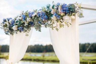 Düğün kemer mavi çiçekler ve beyaz ışık ipek ile dekore edilmiştir. Yaz düğün töreni