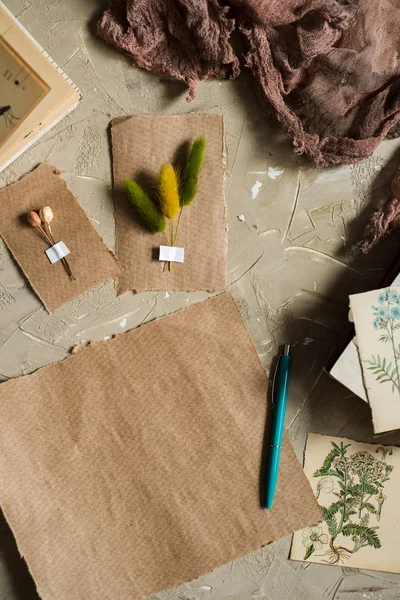 Flay lay, vista superior del herbario, flores secas de lavanda, cuaderno, libro de notas, lápiz y fotos de primavera de verano sobre un fondo de concretoPostal sobre papel kraft — Foto de Stock