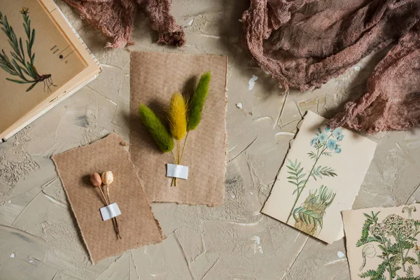 Flay lay, vista superior del herbario, flores secas de lavanda, cuaderno, libro de notas, lápiz y fotos de primavera de verano sobre un fondo de concretoPostal sobre papel kraft — Foto de Stock