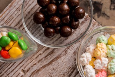 Paskalya tatlısı lezzetli çikolatalı yumurta ve ahşap masa üzerinde renkli şeker sürahisi.