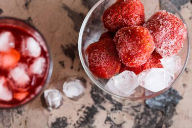 Buz üzerine sığ derinlik-in tarla içinde ahşap arka plan ile taze çilek suyu