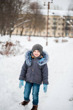 Having oyunculuk ile kar, açık havada kar yağışı sırasında renkli kış giysileri sevimli küçük komik çocuk. Etkin açık havada eğlence kışın çocuklu. Çocuk ile sıcak şapka, eldiven el ve eşarp