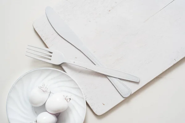 Placa de cuchillo de tenedor blanco en una antigua bandeja de madera. Idea de arte tomates blancos, todo en un solo color — Foto de Stock
