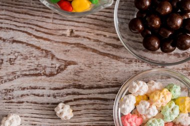 Çerçeve kase ve kavanozlar, şeker renkli parlak çeşitli şeker köpekler ve gökkuşağı sarmal lolipop dağınık şeker Kalpler ve jelibon kayrak bir merkez kopya alanı çevresinde siyah renkli