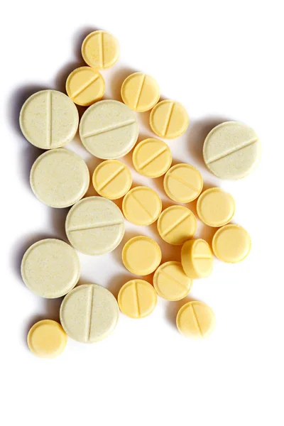 Closeup žlutých tablet na izolované bílém pozadí. Tablety různých tvarů a velikostí. Žlutá hnědá a oranžová izolované na bílém pozadí — Stock fotografie