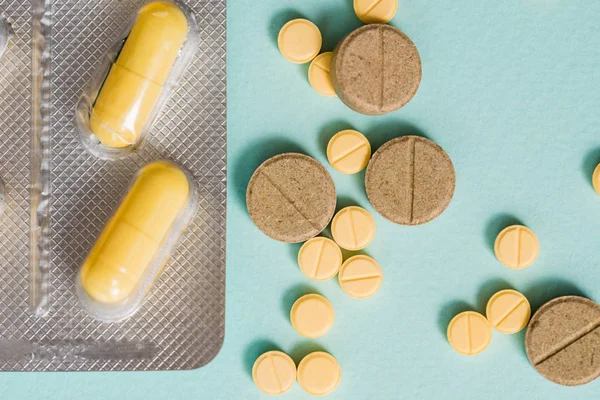 Macro shot detail of yellow oval tablet pills with blister packs on white background with copy space. Pain killer medicine. — Stock Photo, Image