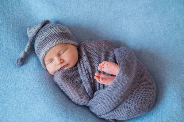 Mały śpi noworodka pokryte bogate fioletowy kolorowe wrap — Zdjęcie stockowe