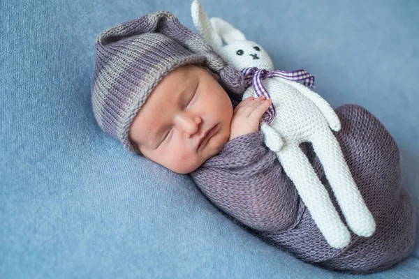 Mały śpi noworodka pokryte bogate fioletowy kolorowe wrap — Zdjęcie stockowe