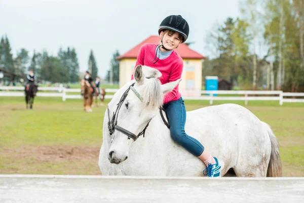 Una chica dulce montando un caballo blanco, un atleta practicando deportes ecuestres, una chica abraza y besa a un caballo . —  Fotos de Stock