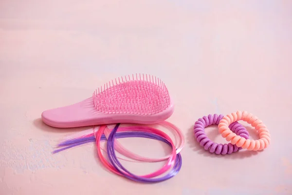 Light pink comb, purple decorative hair for girls hairstyles. Decoration for teenage girls. Silicone rubber band. copy space. flat lay. top view.