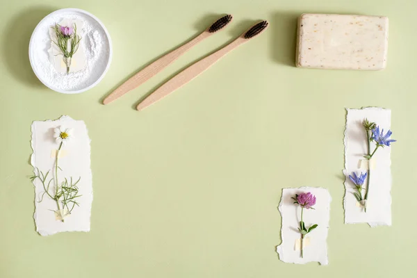 Higiene ecológica. Limpieza de Residuos Zero. cepillo de dientes, polvo para la limpieza de dientes, jabón natural, loción vegetal, flores frescas. Flat lay Copiar espacio. fondo verde — Foto de Stock