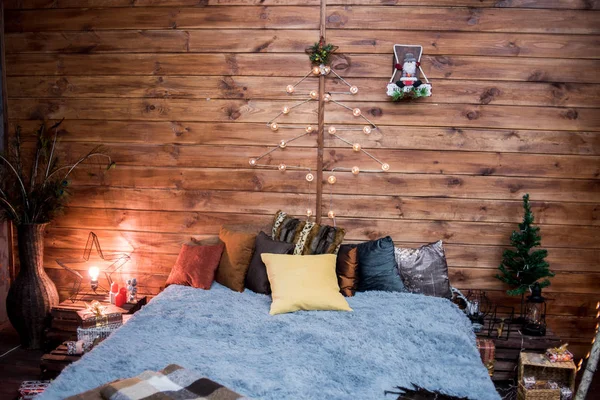 Kerstboom met cadeautjes eronder in de woonkamer. Witte kamer. Heldere lichten en bokeh. Gezellige houten kamer. Kerstmis op het platteland, een vakantie in het dorp. — Stockfoto