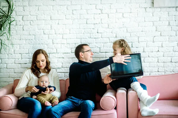 Generaciones malentendidas. Papá irritado gritándole al hijo ofendido trabajando en el portátil sentado en el sofá interior. Enfoque selectivo — Foto de Stock