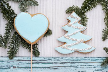 Beyaz eldivenli Noel kurabiyesi. Mavi ahşap bir arka planda. Topları ve evi olan bir Noel ağacı. Yeni yıl kartı