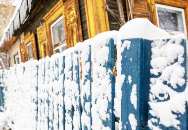 Karla kaplı eski kırsal ahşap çitler. Köyde kış. Kar ve buz saçakları her yerde. Yeni yıl ve Noel havası. Şiddetli don. Su birikintilerinde buz var. Kaygan yollar.