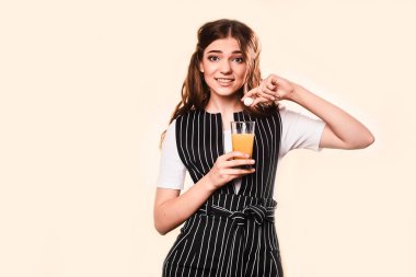 Başı ağrıyan bir kadın su bardağı tutuyor. Migren ve ateş, ağrı kesiciler. Stüdyoda arka planda bir kız. tıbbi bakım konsepti.