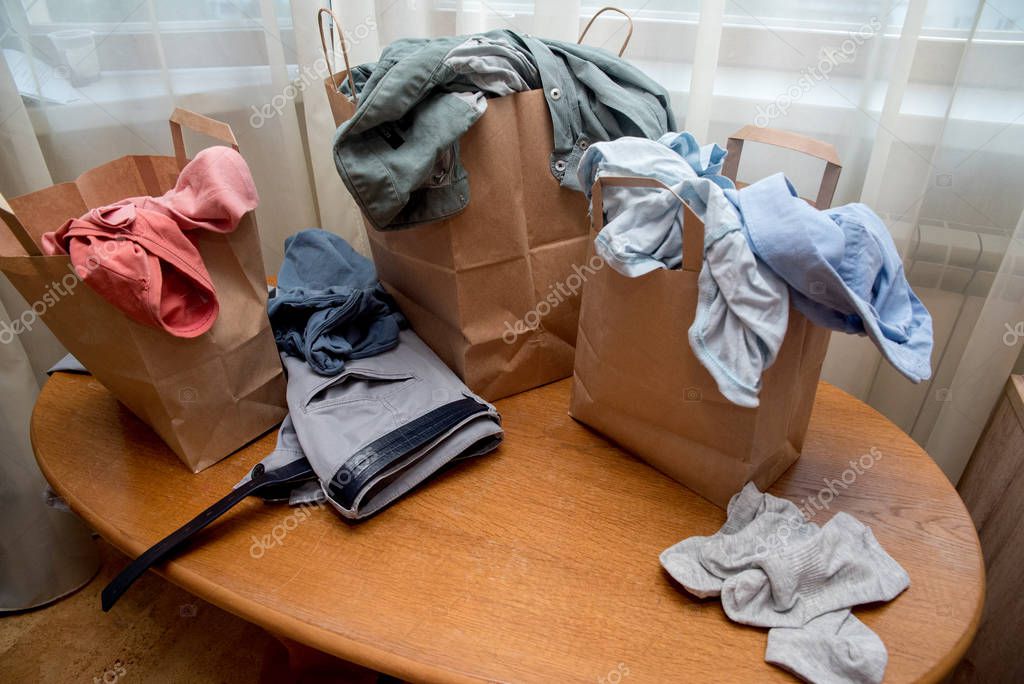 Se mete en la mesa. Una gran pila de ropa para hombres y mujeres. Una ...