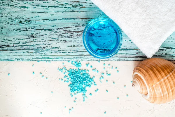 Hermosa composición de spa azul. sal marina azul, jabón líquido, estrellas de mar, conchas y una toalla de baño blanca — Foto de Stock