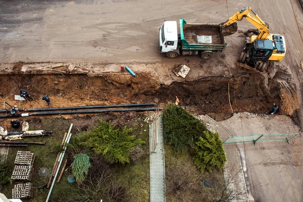 Riparazione di impianti di riscaldamento.Scavato profonda trincea servizi di ingegneria sistemi urbani. Allarme fognature urbane. Lavori di riparazione per la ricostruzione dell'auto stradale urbana . — Foto Stock