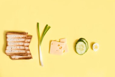 Sandviç yapmak için gerekli malzemeler. Taze soğan, şampiyon mantarı, beyaz ekmek, peynir ve yumurta. Vejetaryen burger. Sarı arkaplan, üst görünüm, kopyalama alanı.