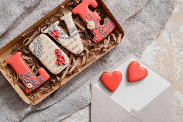 Homemade gingerbread with letters love for Valentines Day located on a dark background, top view