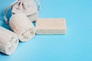 Sıfır atık ev, mavi arka planda kozmetik ekolojik ürün. Bambu fırçası, sebze lifleri, pamuk havlu. Düz konum kopyalama alanı.