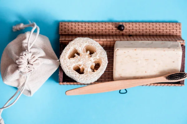 Residuos cero hogar, producto ecológico cosmético sobre un fondo azul. cepillo de bambú, esponja vegetal, toalla de algodón. Flat lay Copiar espacio . — Foto de Stock