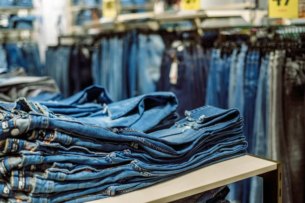 Sklep z dżinsami w centrum handlowym. Sprzedaż dżinsów. Niebieskie spodnie. Zakupy dla kobiet. — Zdjęcie stockowe