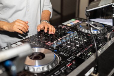 Bir gece kulübünde elleri olan DJ masası. Stüdyo DJ ekipmanları ışık saçıyor