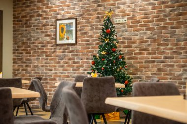Restoranın içinde Noel ağacı, duvarın önünde.