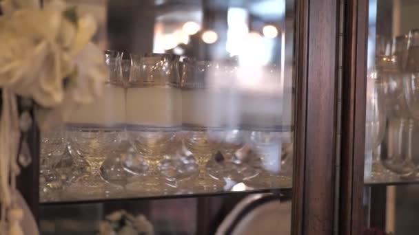 古いファッションワイングラスは 弓で飾られたヴィンテージ木製のサイドボードの中に立つ — ストック動画