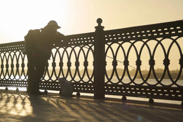 Silhouette of fisherman over sunset in the city