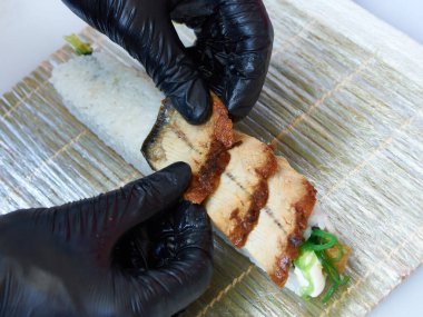 Sishi Roll hazırlayan siyah eldivenli aşçıların yakın plan fotoğrafı.