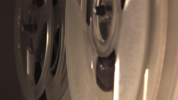 在卷筒到卷筒的录音机上 卷筒是在有百叶窗的背景下旋转的 磁带是旋转的 是特写的 是选择性的 录音机 高质量的音响 间谍录音机 — 图库视频影像