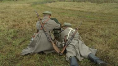 Eski Rus ordusunun iki askerinden oluşan Rus makineli tüfek ekibi Maxim makineli tüfeğine hizmet ediyor. Atış hazırlığı, makineli tüfek bandı. 1914-1918 Birinci Dünya Savaşı 'nın yeniden inşası..