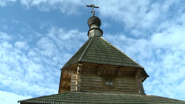 白い雲が空に浮かんでいるのを背景にドームの上に十字架と丸太で作られた古いロシアの木造教会 時間の経過 — ストック動画