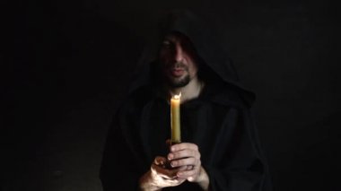 sakallı bir keşiş bir dua mum ışığında, bir mum bi alevi okur. 