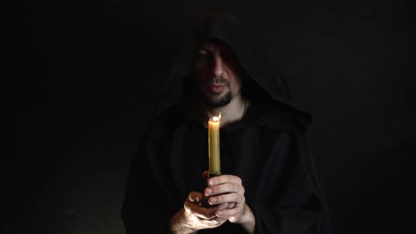 Een Bebaarde Monnik Leest Een Gebed Bij Kaarslicht Vlam Van — Stockvideo