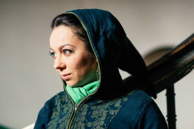 Yüzünde makyajla doğulu güzel bir kadın ışığa doğru bakıyor..