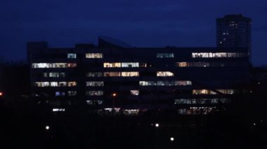 İş merkezinin pencerelerinde ışık, boş ofisler, akşam.