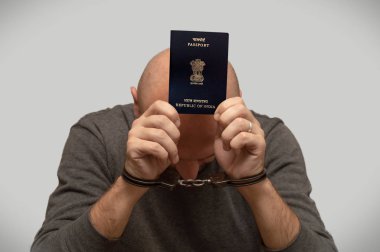 Kelepçeli bir adam Hindistan 'dan gelen kaçak göçmen sorunu elinde pasaportuyla kelepçeli bir Hintli göçmen. Yasadışı sınır geçişi